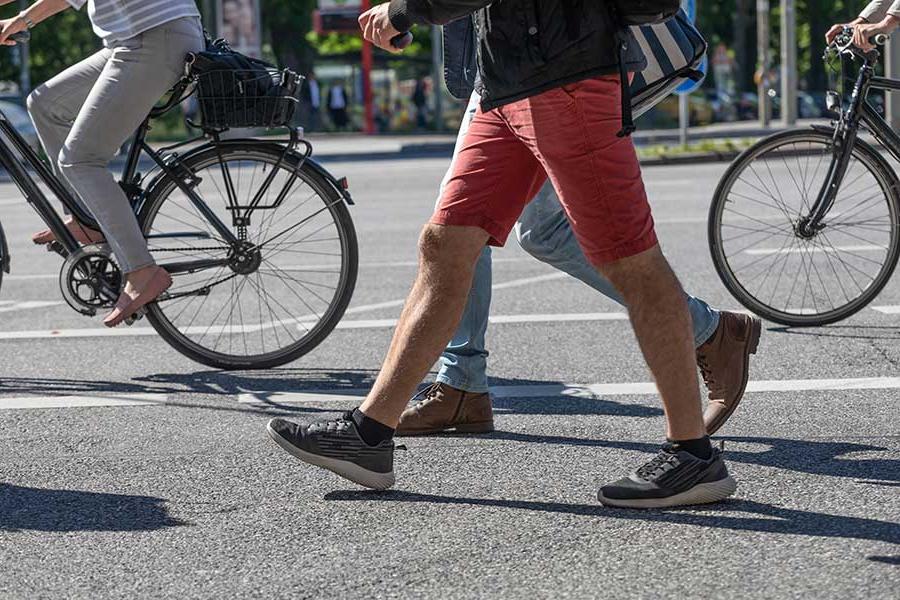 人们在人行横道上骑自行车和走路